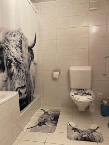 a bathroom with a picture of a cow on the wall at Wohnen mit Blick auf Eiger - ehemaliges Bauernhaus - 2 Schlafzimmer in Schwarzenburg