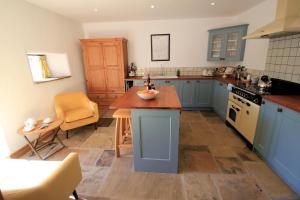 una cocina con armarios azules y una mesa. en Fremington Hall Farm, Reeth, Swaledale en Reeth