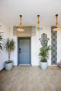 una porta d'ingresso di una casa con due piante in vaso di Spacious & Styling Duplex 6 BR Villa For Friends and Family a Città del 6 ottobre
