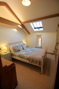a bedroom with a large bed with a skylight at Fremington Hall Farm, Reeth, Swaledale in Reeth
