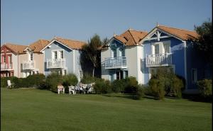 eine Reihe von Häusern mit Rasen davor in der Unterkunft Maison de vacances 4/6p au Golf de Port Bourgenay in Talmont