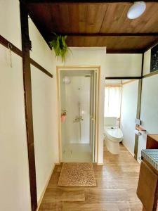 uma casa de banho com um WC e um chuveiro em 一棟貸し切り バリの雰囲気を楽しめる古民家vintagehouse1925Bali em Nagano