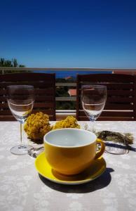 una mesa con un tazón amarillo y dos vasos. en Apartmani Vrančić, en Mandre