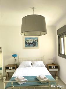 a bedroom with a white bed with a large lamp at • Spacious Apartment in Trendy Akko/Acre • in Acre