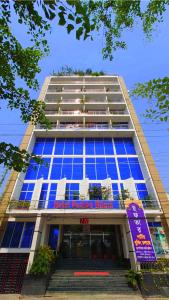 a tall building with blue windows and stairs in front at Hotel Pushpo Bilash in Khulna