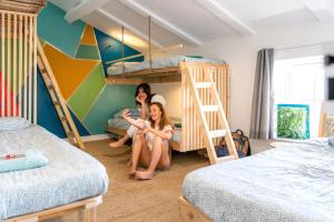 two girls sitting in a room with bunk beds at SURF HOSTEL BIARRITZ in Biarritz