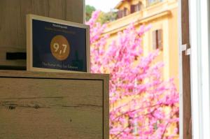 羅馬的住宿－羅馬式聖喬瓦尼酒店，窗前有粉红色花的标志