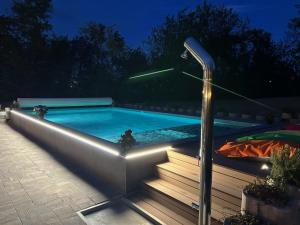 una piscina con luz junto a unas escaleras en Hotel Tre Ville, en Parma