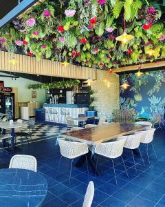ein Restaurant mit Tischen, Stühlen und Blumen an der Wand in der Unterkunft Camping Le Florenville in Florenville
