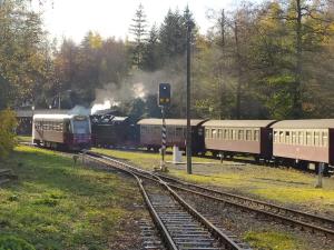 a train traveling down the tracks with two train cars at Ferienwohnung "Frieda" in Breitenstein
