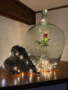 a glass vase with a rose in it with lights at Landgasthof Anker in Simmersfeld