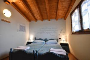 - une chambre avec un lit et un bureau sur le mur dans l'établissement Agriturismo Ai Pradons, à Meduno