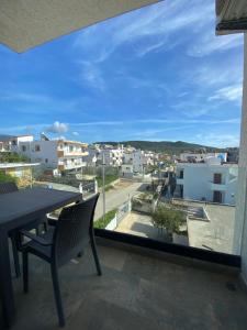 a balcony with a table and chairs and a view of a city at Villa Mucodemi 1 in Ksamil