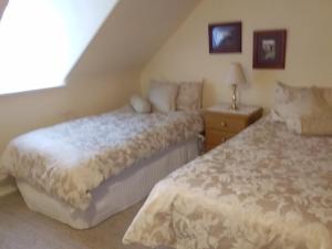 荷伯特的住宿－Josie's Cottage，一间卧室配有两张床和床头灯。