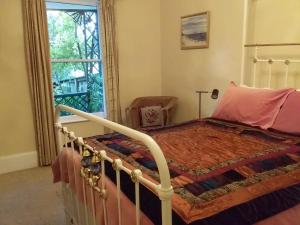 a bedroom with a bed and a window at Josie's Cottage in Hobart