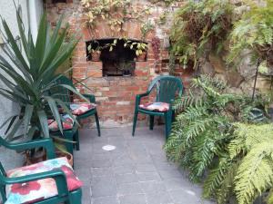 荷伯特的住宿－Josie's Cottage，两把绿色椅子坐在砖墙旁边,墙上有植物