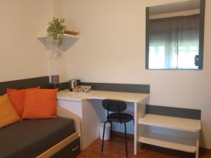 Habitación pequeña con escritorio y silla. en B&B DA ROBERTINO, en Tricesimo