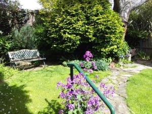荷伯特的住宿－Josie's Cottage，一个带长凳和紫色花的花园