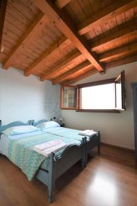 - une chambre avec un lit dans une pièce dotée de plafonds en bois dans l'établissement Agriturismo Ai Pradons, à Meduno