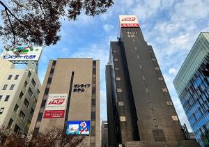 een hoog gebouw met een klok erop bij TKP Sunlife Hotel in Fukuoka