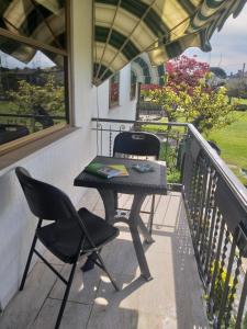 d'une table et de deux chaises sur un balcon. dans l'établissement B&B DA ROBERTINO, à Tricesimo