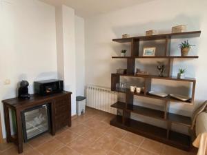 a living room with a fireplace and wooden shelves at Estudio LA HIGUERA in Argés