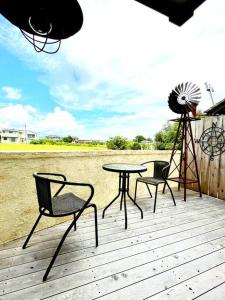a patio with two chairs and a table and a windmill at 一棟貸し　魔女の休日CLUB in Nagano