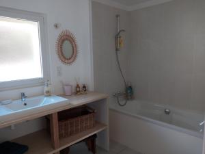 a bathroom with a sink and a bath tub at Longère chez Séraphin 