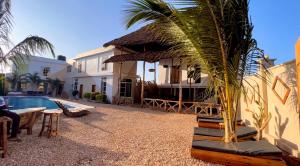a house with a palm tree next to a pool at VICK Boutique Hotel with New power backup in Banda Kuu