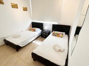 Habitación con 2 camas y espejo. en Gorgona Seafront Villas 3 Bedroom With Private Swimming Pool, en Ayia Napa