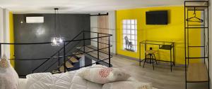 - un salon avec un canapé et un mur jaune dans l'établissement Kyma Holiday Loft, à Artemi