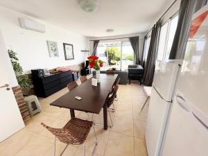 cocina y comedor con mesa y nevera en Gorgona Seafront Villas 3 Bedroom With Private Swimming Pool, en Ayia Napa