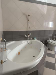 El baño incluye bañera blanca y aseo. en Casa Morais Pinto, en Reguengos de Monsaraz