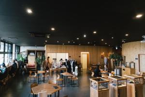 a group of people sitting at tables in a restaurant at FOLK FOLK Hostel, Cafe & Bar in Ise