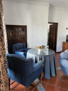 a living room with blue chairs and a table at Casa Morais Pinto in Reguengos de Monsaraz