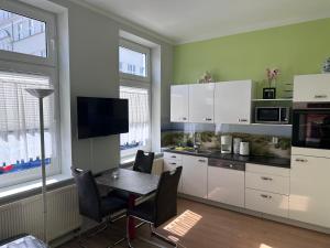 a kitchen with white cabinets and a table with chairs at Meeresbriese Warnemünde in Warnemünde