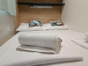 two beds with white towels and pillows on them at Mobile home Jadre I in Pakoštane