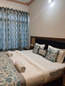 a bedroom with a large bed with blue curtains at zikzik holidays in Leh