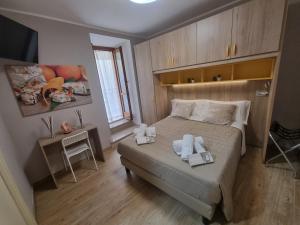 a small bedroom with a bed and a television at LucyBen GuestHouse in Cascia