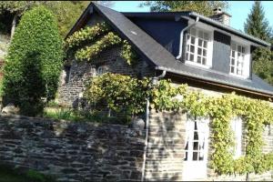 Kamienny dom z bluszczem na boku w obiekcie Cottage perché dans les montagnes du Mont-Saint-Michel w mieście Beauficel
