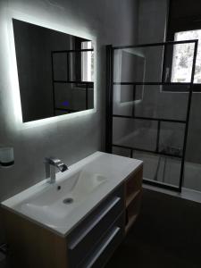 a bathroom with a white sink and a mirror at Appartement proche remontées refait à neuf in Crans-Montana