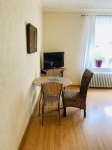 sala de estar con mesa, sillas y TV en Apartment Elli, en Františkovy Lázně