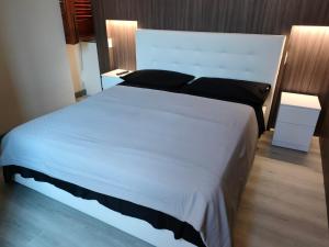 ein großes weißes Bett in einem Schlafzimmer mit zwei Lampen in der Unterkunft Cilento relax San Marco Castellabate JML in San Marco di Castellabate