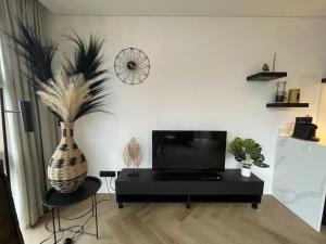 a living room with a vase on the wall at Edelhert, moderne en comfortabele vakantiewoning met hottub! in Ermelo