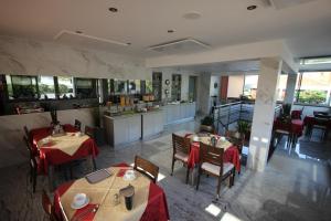 a restaurant with tables and chairs and a kitchen at Pension Silvia in Portorož