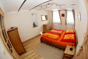 a bedroom with an orange bed in a small room at Jessop Haus in Lübeck