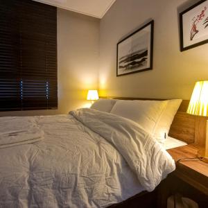 平沢市にあるHumphreys 2 min Vintage Korean Roomのベッドルーム1室(ランプ2つ、窓付)