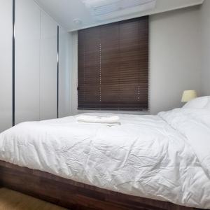 Schlafzimmer mit einem großen weißen Bett und einem Fenster in der Unterkunft Humphreys 2 min Vintage Korean Room in Pyeongtaek