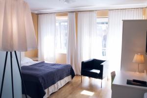 グラーツにあるHotel Villa Rückertのベッドルーム1室(ベッド1台、椅子、窓付)