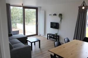 a living room with a couch and a dining room table at West Bay Familieappartement in Middelkerke